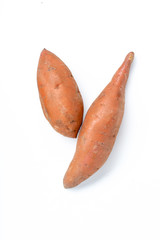 Two raw unpeeled isolated sweet potatoes on white background
