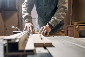 Electric saw cutting wood board. Carpentry workshop