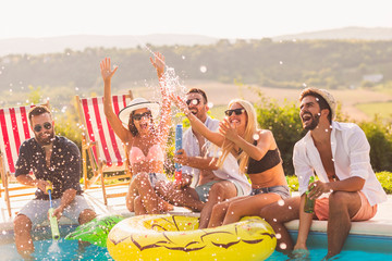 Friends splashing water by the pool