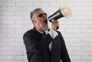 Business man shouts in loudspeaker, a man yells into a mouthpiece