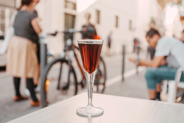 People talking and drinking cherry liquor at outdoor bar. Street cafe leisure concept