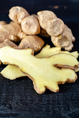 Fresh ginger roots close up on black wooden background