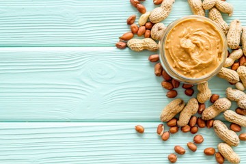 peanut butter for cooking breakfast at home on mint green wooden background top view mock up