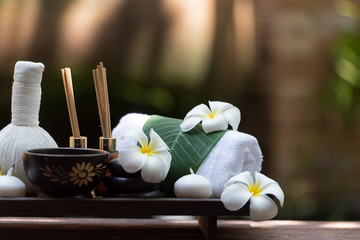 Thai spa composition treatments aroma therapy with candles and Plumeria flowers on wooden table close up. Healthy and Relax Concept