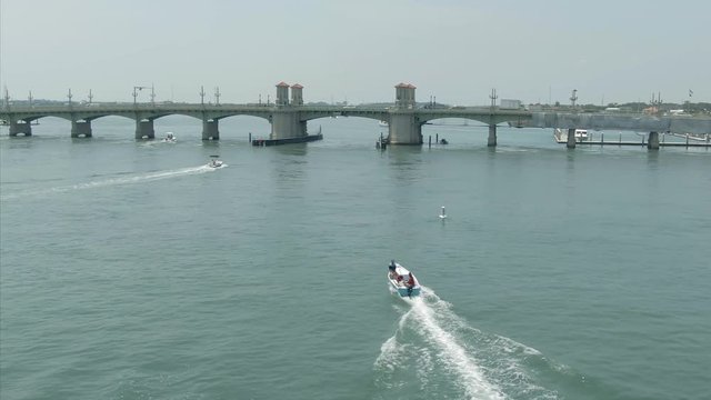 Aerial: speed boat on the water going under Bridge of Lions. St Augustine, Florida, USA. 3 July 2019