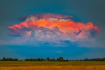 Severe pulse thunderstorm Cumulonimbus clouds iluminated by evening red light, a rare moment