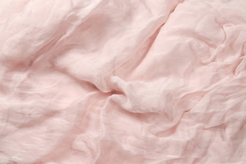 Soft smooth pink silk fabric background. Fabric texture.