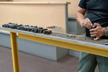 the pistol holder with 9 19 cartridges. The hands of the men charge the gun with ammunition