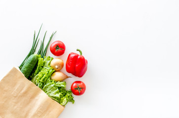 Healthy food with fresh vegetables in paper bag on white background top view space for text