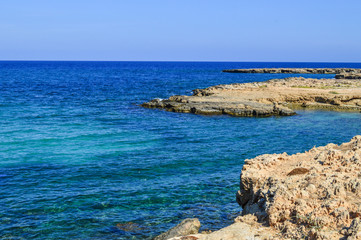 Fototapeta na wymiar Protaras, the island of Cyprus. Mediterranean coastline. A sunny day, blue sky, coral coast. Background. Copy space.