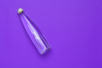 Water bottle flat lay top view on color paper background