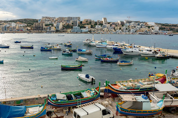 Fototapeta na wymiar The panorama of harbour on St Paul's Bay with fishing boats and tourist ships, Bugibba, Malta