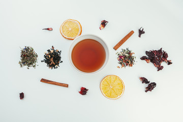  layout made of cup of black tea and leaves on a white background. Top view