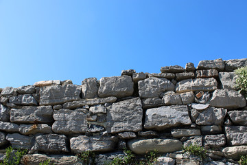 Muro a secco in pietra con cielo blu
