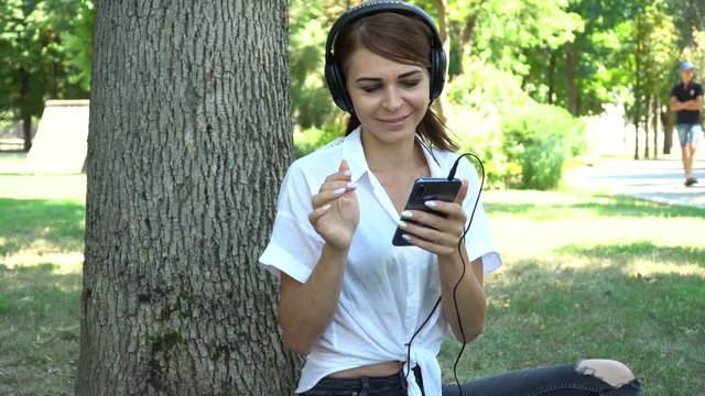 Young girl listening to music on the phone in the Park
