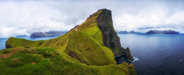 Small lighthouse located near huge cliffs on island of Kalsoy, Faroe Islands