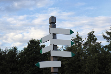 An empty signboard with pointers in the park.