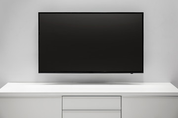 Flat tv screen on wooden shelf in living room at home