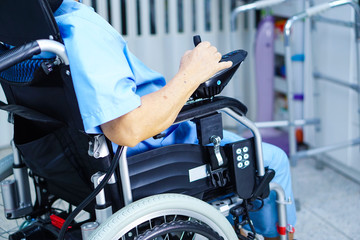 Asian senior or elderly old lady woman patient on electric wheelchair with remote control at nursing hospital ward : healthy strong medical concept 