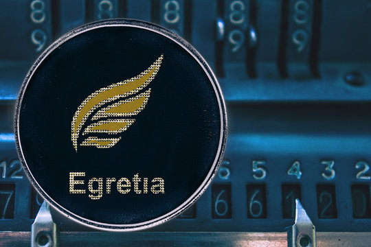 Coin cryptocurrency EGT Egretia against the numbers of the arithmometer.