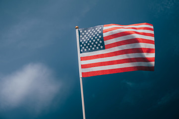 Obraz premium American flag, on against a overcast sky.
