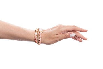 Perfect woman hand wearing golden bracelet with pink opals, pearls and gold beads isolated on white...