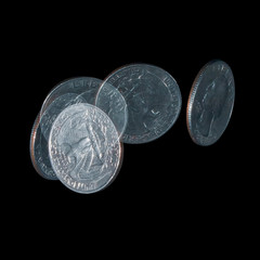 Spinning coin in stroboscopic light on a black background, close up. Quarter dollar coin