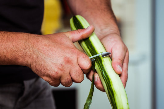 Cuisinier en train d'&eacute;plucher des concombres