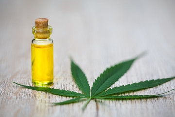 CBD oil hemp products, Medicinal cannabis with extract oil in a bottle on a wooden table. Medical cannabis concept