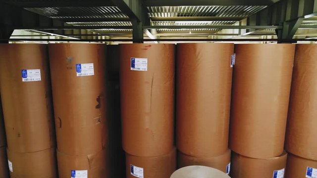 motion past packaging paper rolls with stickers in warehouse