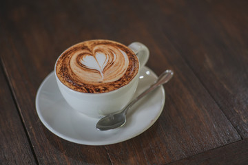 a cup of coffee latte art on wood table