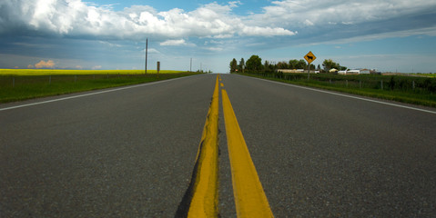 Looking down the yellow solid center line of a rural highway