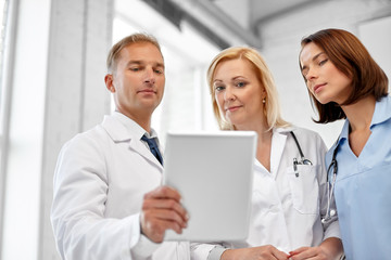 healthcare, medicine and technology concept - group of doctors with tablet computer at hospital