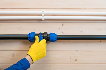 hands of the master block the water supply pipe for repair