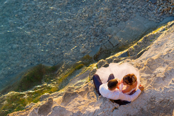 Young couple sitting on the beach looking at each other