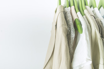 summer wardrobe with linnen clothes on green hangers