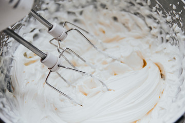  whipping cream with a mixer. white butter cream for cake