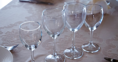 Restaurant vintage, cutlery, glasses on the table, bar, bottles, large candles on a white tablecloth, sliced fruit with powdered sugar