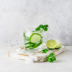 Glass of cool infused water with fresh cucumber, lime and parsley, (lemonade, cocktail). Detox drink, health care, fitness, diet concept.