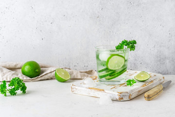 Glass of cool infused water with fresh cucumber, lime and parsley, (lemonade, cocktail). Detox drink, health care, fitness, diet concept.