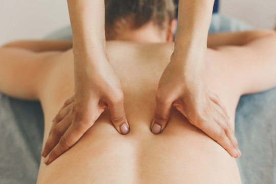 Woman receiving a back massage in a medical center.