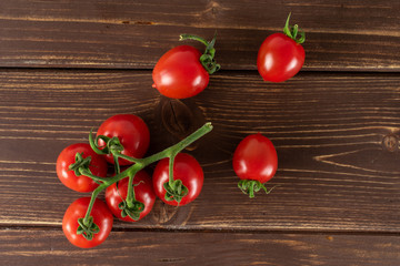 Group of eight whole fresh red tomato cherry flatlay on brown wood