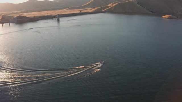 Aerial Drone Tracking Shot of a Boat with Two Waterskiers on.a Mountain Lake (Lake Kaweah, Visalia, California)