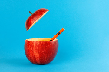 Health Red Cut Apple recyclable paper straw juice drink idea concept on blue background