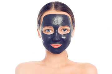 Brunette in a black mask for the face. Beautiful photo of a girl with perfect skin. A young girl cares for herself