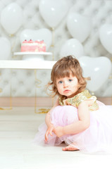 Fototapeta premium Portrait of baby girl with cake on her birthday