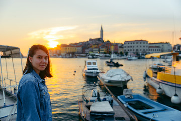 woman portrait in front of beautiful city near sea on sunset