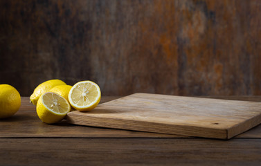 Kitchen table with empty cutting board and lemon. Place for your object