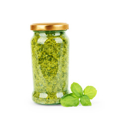 Pesto sauce in a can of basil leaves on a white background