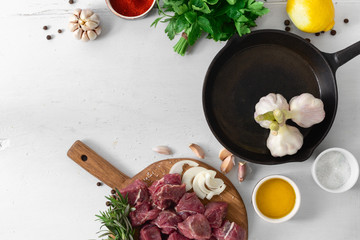 Сut of meat with vegetable on white wooden background top view